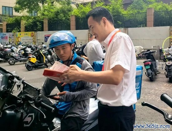 泰康东谈主寿福建分公司的“消保志愿者”在为快递小哥义务解答